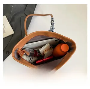 Interior view showing the large storage capacity of the brown leather tote bag with silk scarf