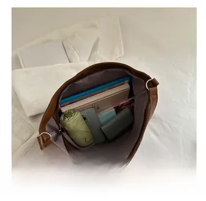 Spacious interior of brown faux leather bowling bag showing tablets and essentials