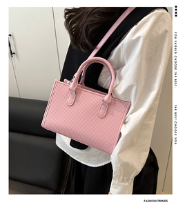 Borsa rosa a pieghe con manico circolare indossata da modella per riferimento stile