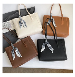 Chic tote bags in four colors with floral scarves and art books on elegant white backdrop