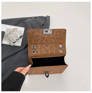 Close-up of leopard print crossbody bag showing silver metal buckle and inner lining