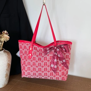 Red festive Xi pattern tote bag with leather handles and decorative silk scarf accessory
