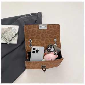 Detail of leopard print crossbody bag showing large interior capacity for two smartphones