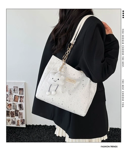 Detail of white star print tote bag with gold chain and cute cloud charm pendant
