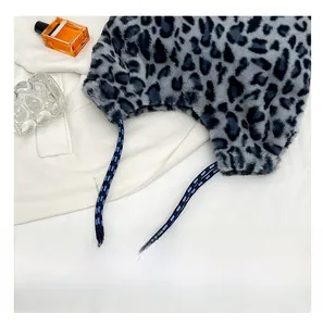 Detail showing grey leopard faux fur texture and striped rope strap of the shoulder bag