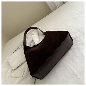 Detail of large dark brown suede tote bag with smooth leather patchwork and wide strap