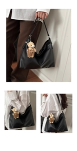 Detail of black large tote bag with teddy bear pendant and adjustable strap