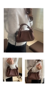 Detail of brown faux suede cloud bag with pleated design and striped ribbon accent