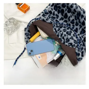 Spacious interior of leopard plush tote bag holding tablet, umbrella and cosmetics