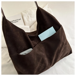 Close-up of brown suede tote bag featuring functional double front pockets for storage