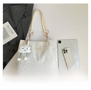 Detailed view of white star-print shoulder bag with plush cloud charm and metal rings