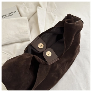 Close-up of deep brown suede tote featuring secure dual magnetic closure and mesh lining