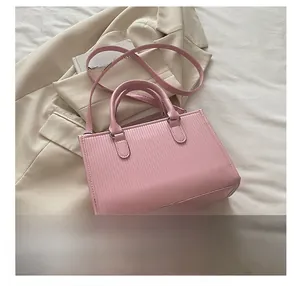 Dettaglio della trama rosa goffrata verticale sulla borsa tote con manici robusti