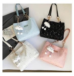 Dettaglio di quattro borse tote in pelle colorata con motivi a stella e ciondoli