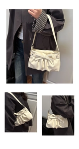 Detailed views of creamy white shoulder bag with bow, star buckle and ruched bottom texture