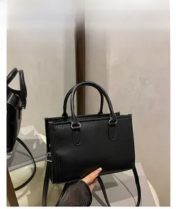 Detailed view of black vertical striped tote bag with round handles and silver hardware