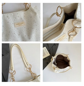 Macro detail of creamy tote bag with silver star rivets and premium metal chain handle