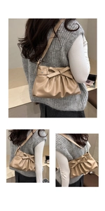 Detail of apricot pleated handbag featuring a large bow and star-shaped metal charm
