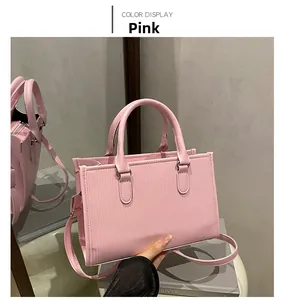 Detailed side view of pink tote bag with vertical texture and silver metal hardware