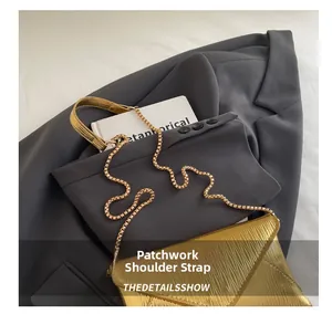 Detail of metallic gold envelope bag with hybrid chain and wide strap design