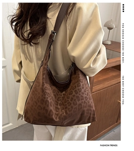 Detail of leopard print suede tote bag with adjustable brown leather strap and metal buckle