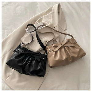 Detailed close-up of bow and star rivets on pleated texture hobo shoulder bags