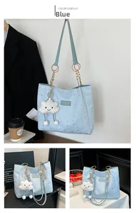Close-up of light blue tote bag with silver star prints and a white cloud plush charm