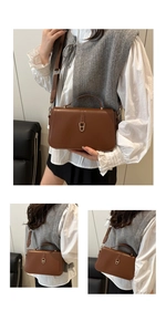 Dettaglio borsa baguette in pelle marrone retrò con elegante fibbia a U in oro lucido