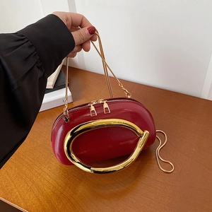Red glossy patent leather shoulder bag with gold metal handle and dual zippers