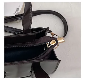 Close-up of golden zipper closure and polished leather on fashion crossbody bag