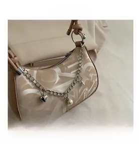Detail of moon bag with heart pendant, pearl charm and silver chain strap