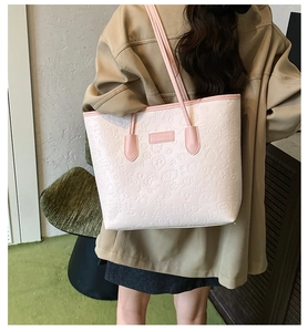 Detail of pink embossed tote bag showing 3D heart and floral patterns with fashion label