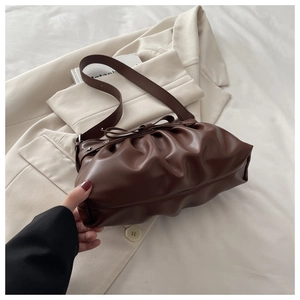 Detail of dark brown bow tote bag with pleated texture and silver star rivets