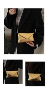 Macro detail of gold envelope chain bag showing metallic wavy texture and sleek finish