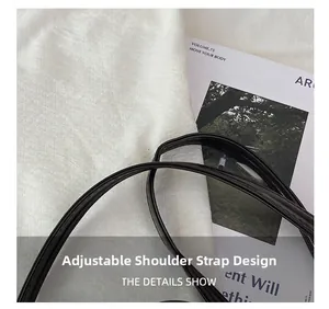 Close-up detail of the adjustable shoulder strap on a black glossy large tote bag