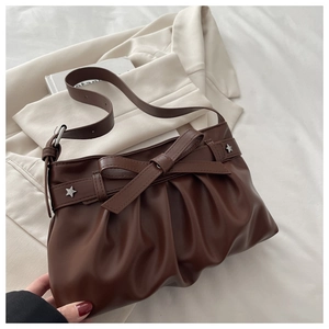 Close-up of brown pleated PU tote bag featuring a bow design and silver star rivets