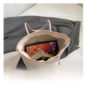 Spacious pink embossed leather tote bag interior with zipper pocket and everyday essentials
