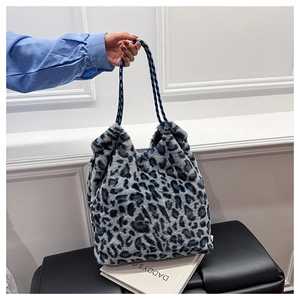 Detail of plush leopard print tote bag with blue-black braided rope handles