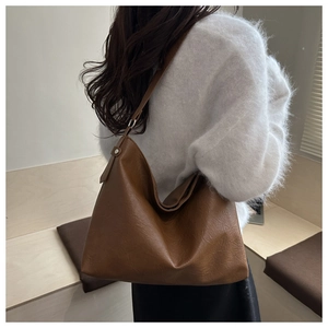 Retro brown large capacity tote bag shown on model in a warm minimalist indoor setting