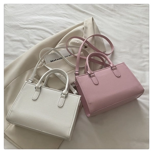 Detail of square crossbody bags featuring vertical textured finish in white and pink