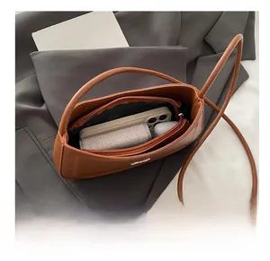 Top view of brown leather crescent bag interior with a zipper pocket and daily essentials