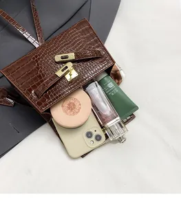 Detail showing the inner capacity of the brown crocodile texture bag with gold lock