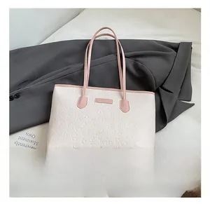 Detail of contrast tote bag featuring pink straps and 3D embossed cute patterns