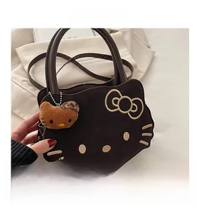 Detail of a brown leather handbag featuring a Hello Kitty silhouette and plush charm