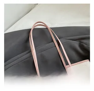 Detailed macro of pink leather handles and embossed heart texture on fashion tote bag