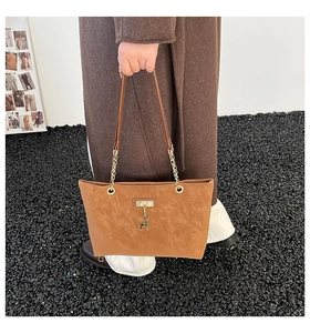 Brown frosted leather tote bag detail with gold deer pendant and chain handle