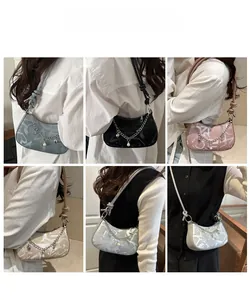 Detail of crescent shoulder bag with knot strap and decorative heart chain in five colors