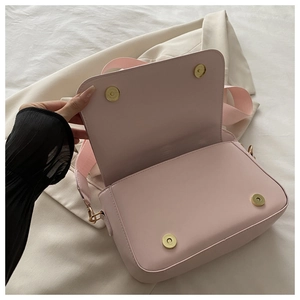 Detail showing pink faux leather bag interior with double gold magnetic snap closures