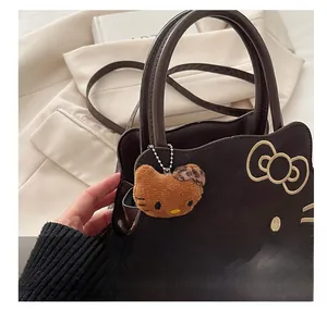 Detail of dark brown leather handbag featuring Hello Kitty silhouette and plush charm