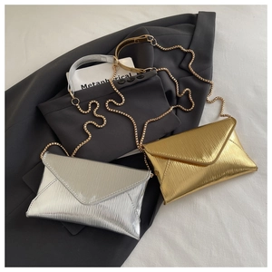 Detail of pleated envelope bags with metal chains in gold and silver finishes